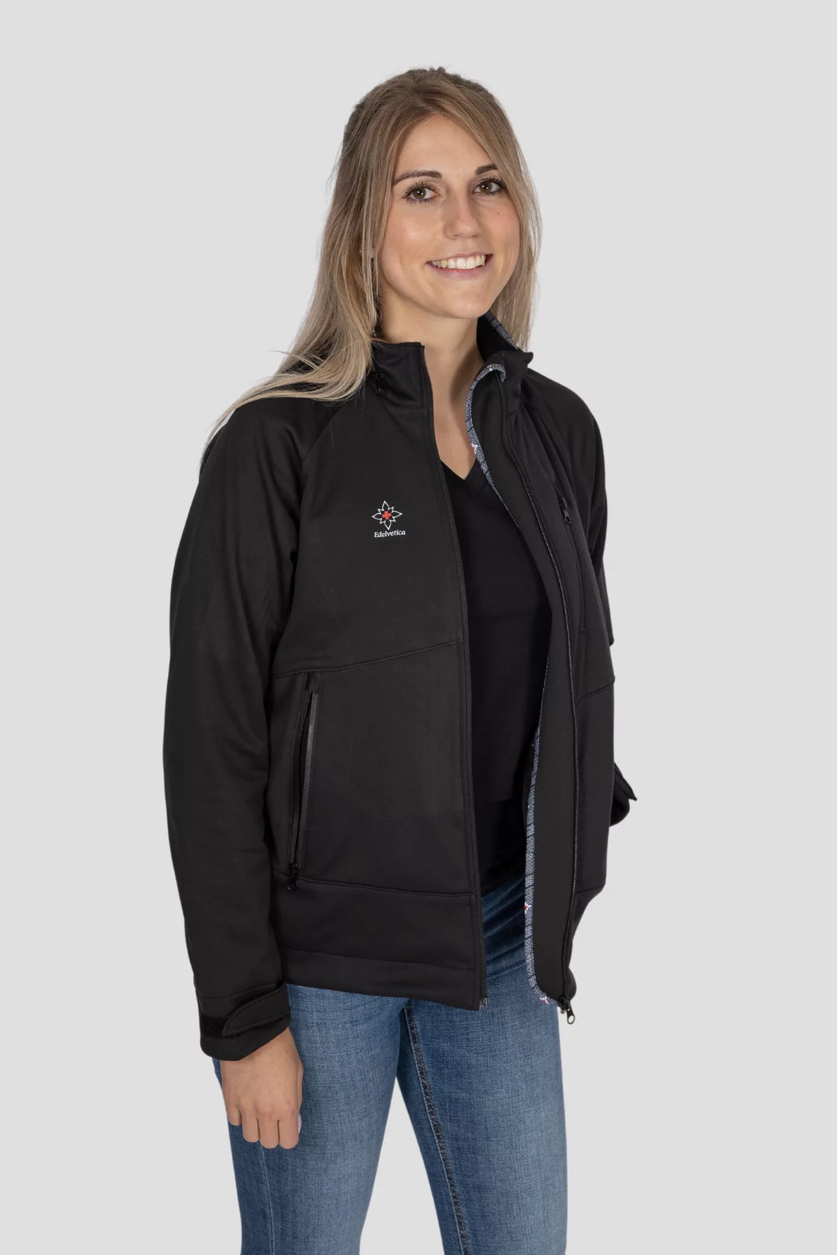 Softshell Jacke Edelweiss Damen von Edelvetica, schwarze Outdoor-Jacke mit grauem Edelweiss-Muster, wasserdicht, winddicht und stilvoll, ideal für Freizeit und Outdoor.